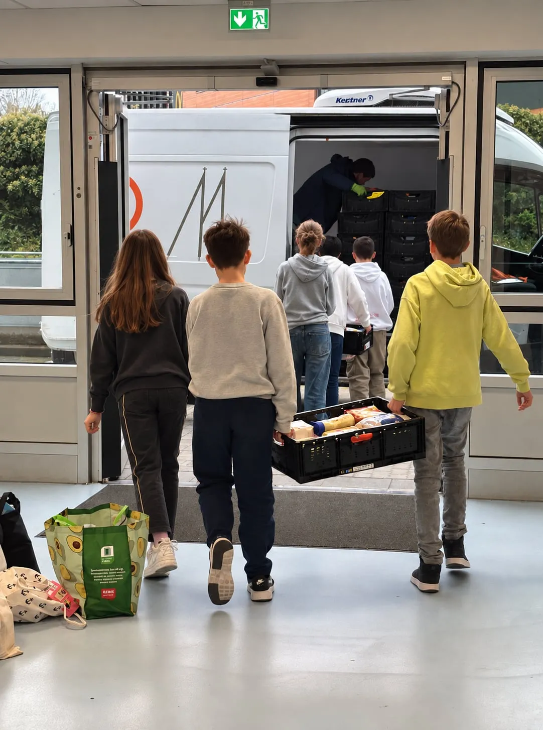 Schüler tragen volle Kisten zum Transporter der Tafel